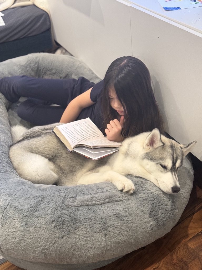 Echo resting while a child reads beside her